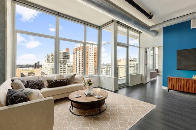 living room featuring a towering ceiling and dark hardwood / wood-style flooring