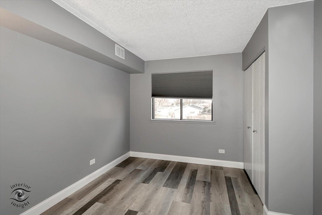 unfurnished bedroom with light hardwood / wood-style floors and a textured ceiling