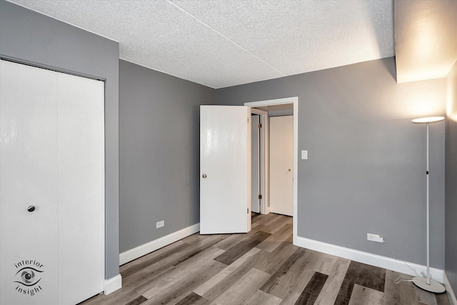 unfurnished bedroom featuring a textured ceiling and hardwood / wood-style flooring