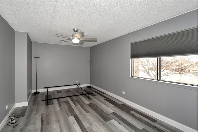 unfurnished room featuring a textured ceiling, hardwood / wood-style flooring, and ceiling fan