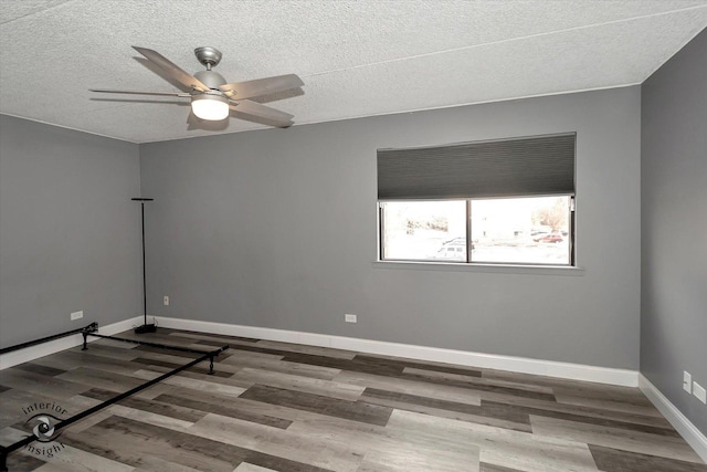 empty room with a textured ceiling, hardwood / wood-style flooring, and ceiling fan