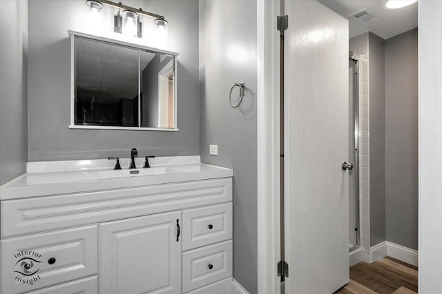 bathroom with vanity, an enclosed shower, and wood-type flooring