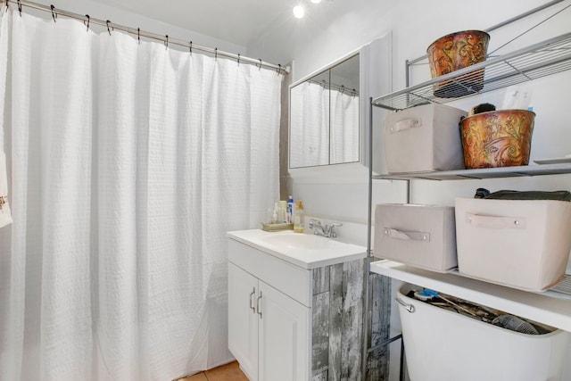 bathroom with tile patterned flooring, vanity, and toilet