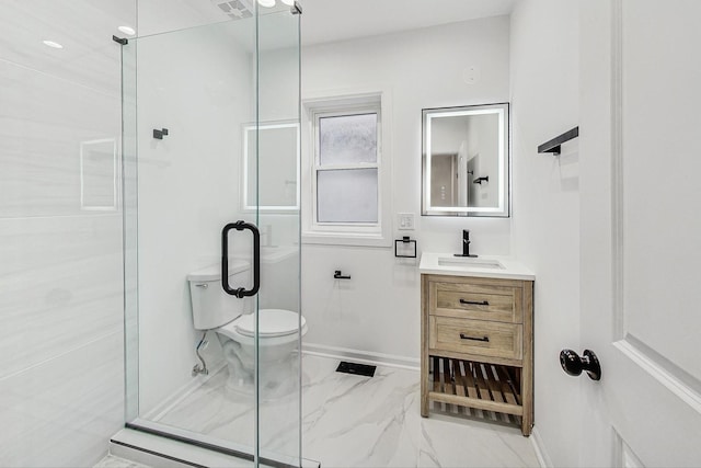 bathroom featuring toilet, a shower with door, and vanity