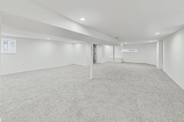 basement featuring light colored carpet and plenty of natural light