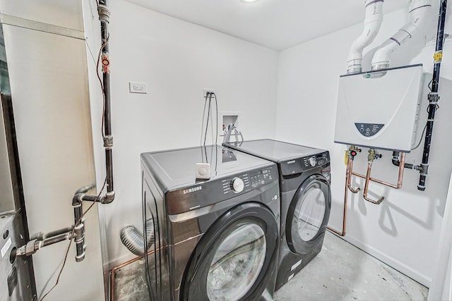 laundry room with water heater and washer and clothes dryer