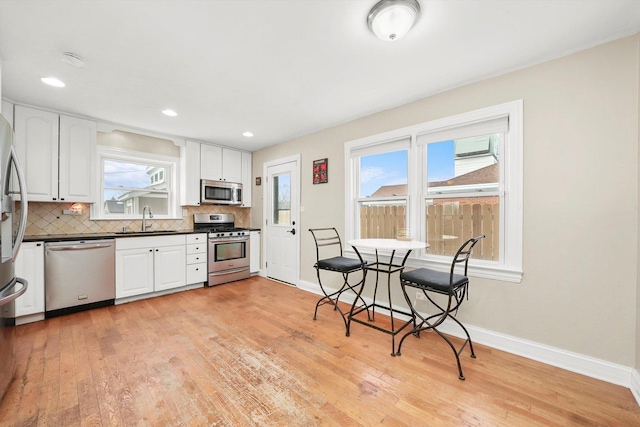 kitchen featuring white cabinets, appliances with stainless steel finishes, tasteful backsplash, and sink