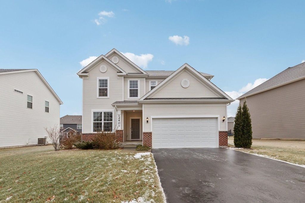 view of front of home with a garage, central AC unit, and a front yard