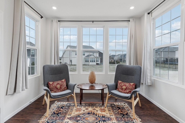 living area with a wealth of natural light and dark wood-type flooring