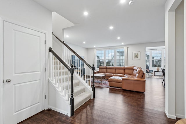 living room featuring dark wood-type flooring and a wealth of natural light