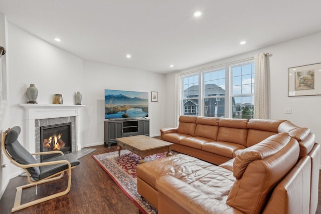 living room with dark wood-type flooring and a tile fireplace