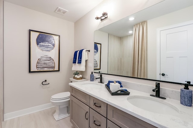 bathroom with vanity, toilet, and wood-type flooring