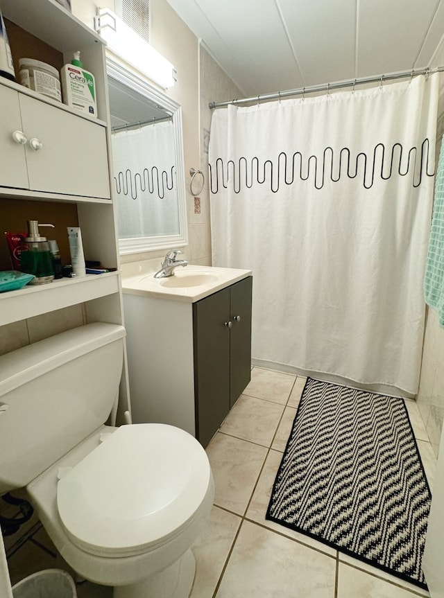 bathroom with tile patterned floors, a shower with curtain, vanity, and toilet