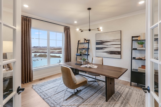 office space with ceiling fan, light hardwood / wood-style floors, crown molding, and french doors