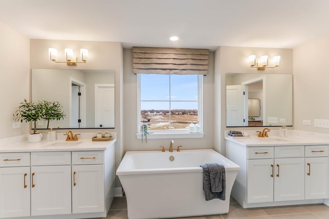 bathroom with a bathtub, vanity, and tile patterned flooring