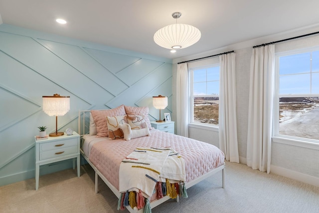 carpeted bedroom featuring multiple windows and wooden walls