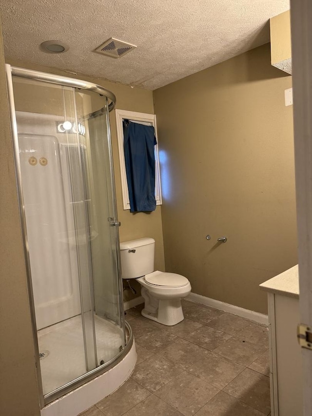 bathroom with a textured ceiling, vanity, an enclosed shower, and toilet