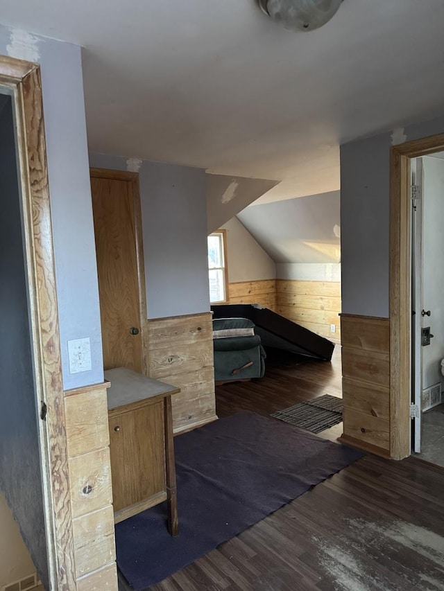 bathroom with wood walls, lofted ceiling, and hardwood / wood-style flooring