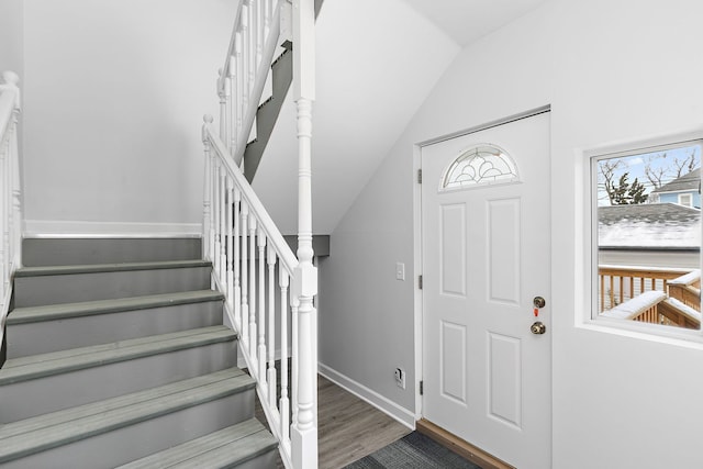 foyer with dark hardwood / wood-style floors and vaulted ceiling