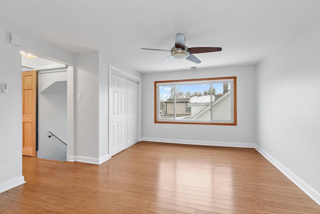 unfurnished bedroom featuring a closet, light hardwood / wood-style floors, and ceiling fan