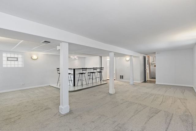 basement featuring bar and carpet