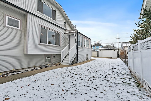 yard covered in snow with a garage and an outbuilding