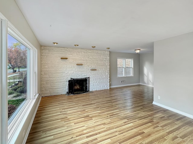 unfurnished living room with a fireplace and light hardwood / wood-style flooring