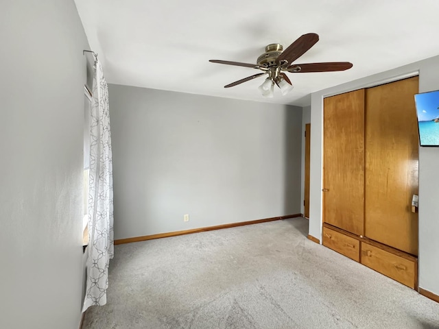 unfurnished bedroom with ceiling fan, a closet, and light carpet