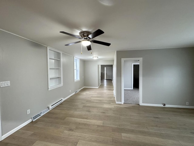 empty room with ceiling fan, built in features, a baseboard radiator, and light hardwood / wood-style flooring