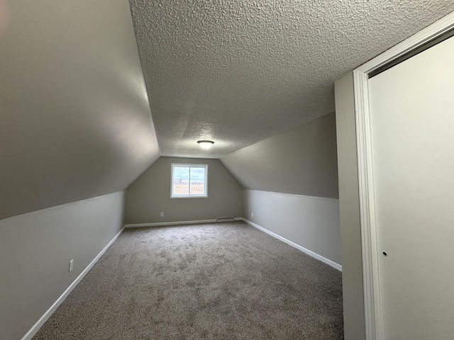 bonus room with carpet flooring, a textured ceiling, and lofted ceiling