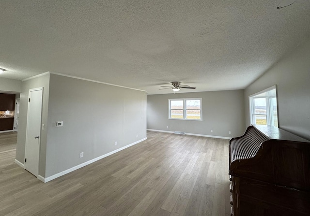 unfurnished room with ceiling fan, light hardwood / wood-style floors, and a textured ceiling