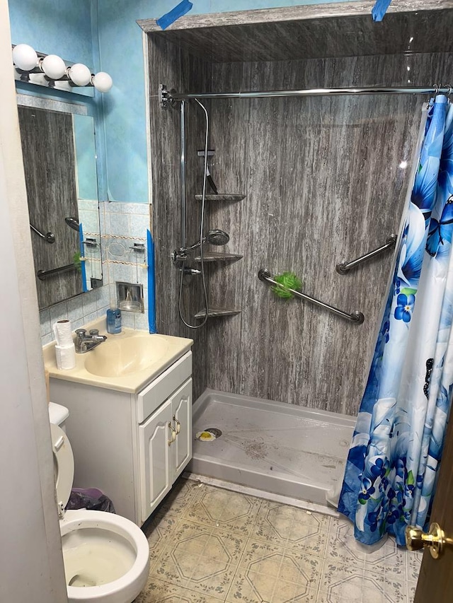 bathroom featuring vanity, toilet, and walk in shower