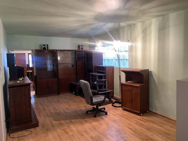 office space with lofted ceiling and light wood-type flooring