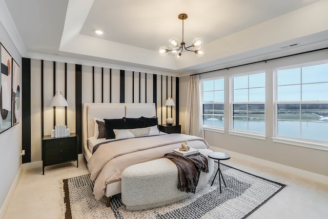 carpeted bedroom with a raised ceiling, a water view, and an inviting chandelier