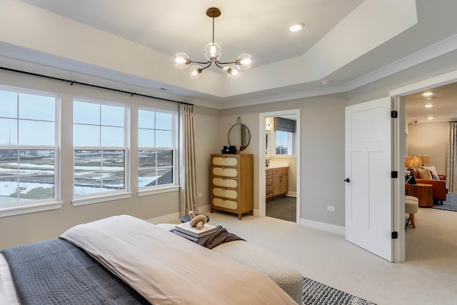 bedroom featuring ensuite bathroom, a tray ceiling, multiple windows, a notable chandelier, and carpet floors