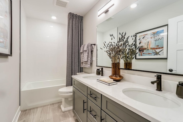 full bathroom featuring tiled shower / bath combo, toilet, and vanity