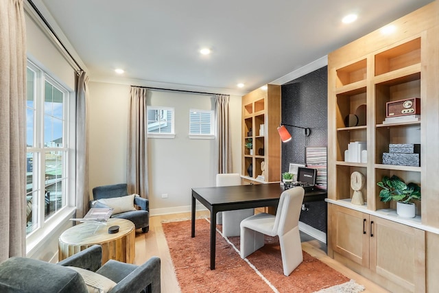 home office with a wealth of natural light and light hardwood / wood-style flooring