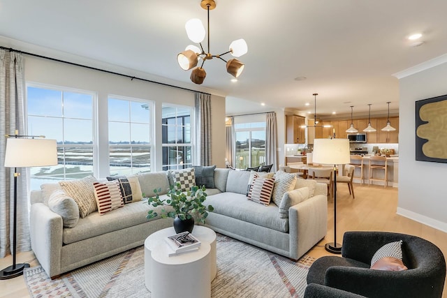 living room featuring light hardwood / wood-style floors, a water view, ornamental molding, and a chandelier