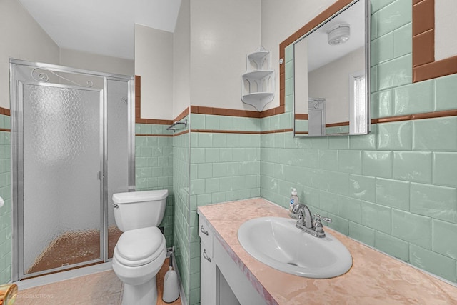 bathroom featuring vanity, tile walls, an enclosed shower, and toilet