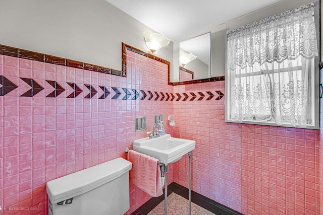 bathroom with toilet and tile walls