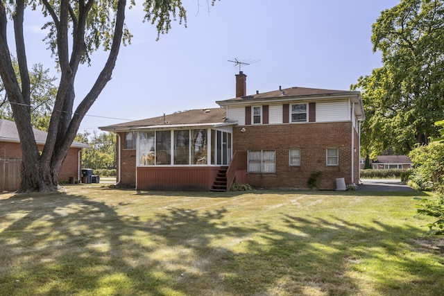 back of property with a yard and a sunroom