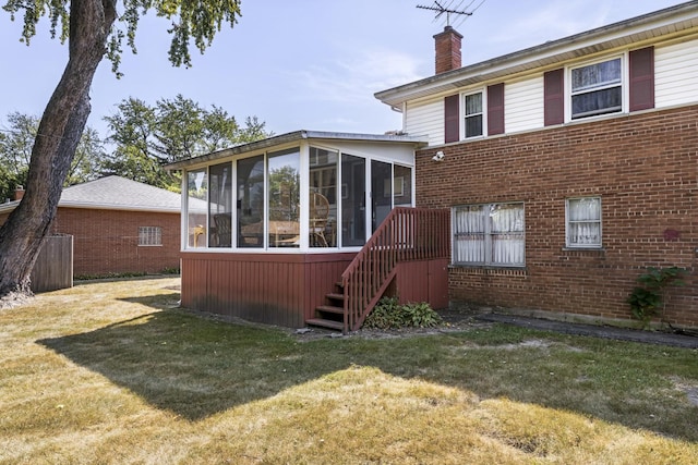 back of property featuring a yard and a sunroom