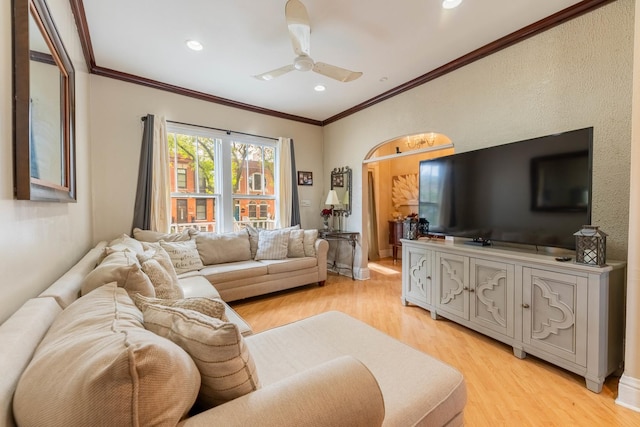 living room featuring ceiling fan, ornamental molding, and light hardwood / wood-style flooring