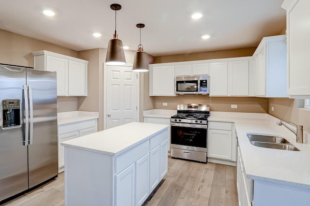 kitchen featuring white cabinets, decorative light fixtures, sink, and appliances with stainless steel finishes