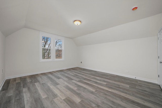 bonus room with dark hardwood / wood-style floors and vaulted ceiling