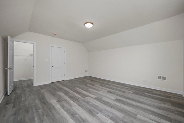 additional living space featuring dark hardwood / wood-style floors and vaulted ceiling