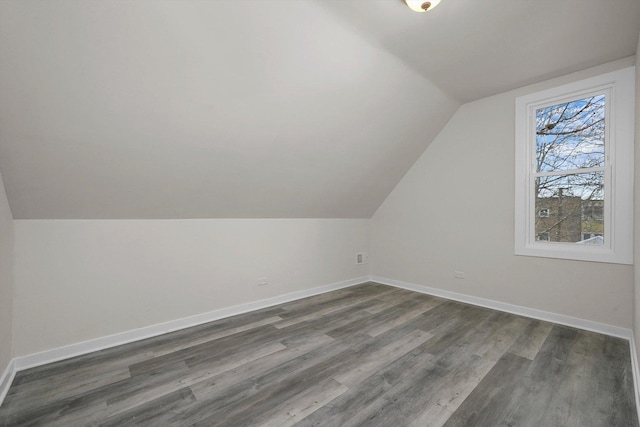 additional living space with dark wood-type flooring and vaulted ceiling