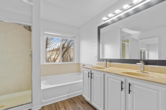 bathroom with hardwood / wood-style floors, vanity, and plus walk in shower