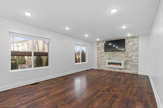 unfurnished living room featuring a fireplace and dark hardwood / wood-style floors