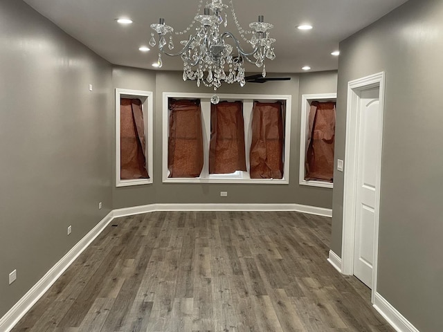 unfurnished dining area featuring wood-type flooring and a notable chandelier